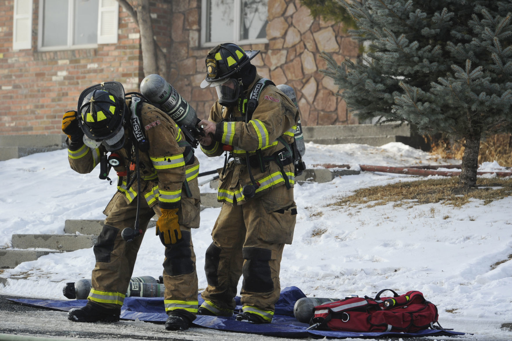 Firefighters exchange their oxygen tanks Friday.